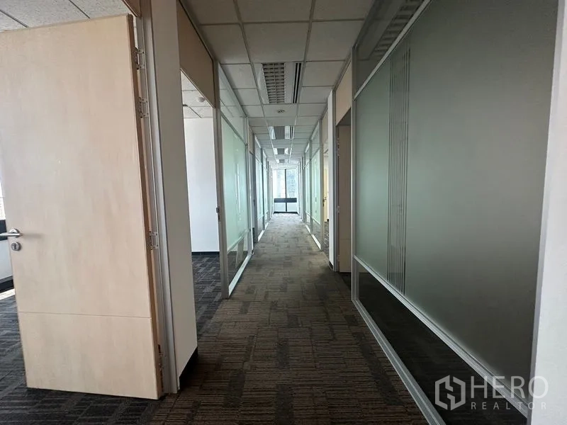 Office Space for rent in Khlong Toei, Bangkok - Corridor with multiple glass-partitioned rooms leading to a window.
