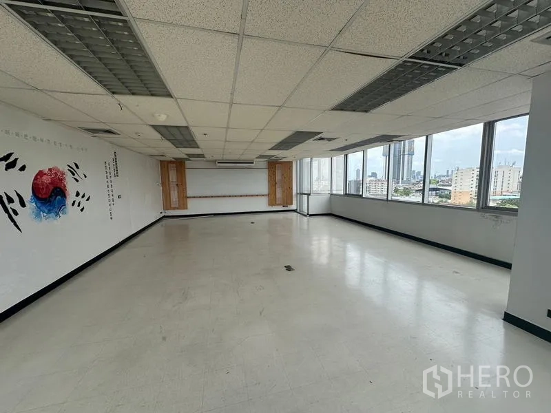 Office Space for rent - Spacious office hall with ceiling lighting, panoramic windows and clean white walls.