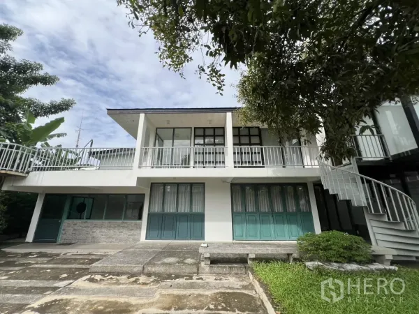 带办公室的家 出租或出售在Phra Khanong, Bangkok - 白色两层家用办公楼正面，长阳台与停车坪