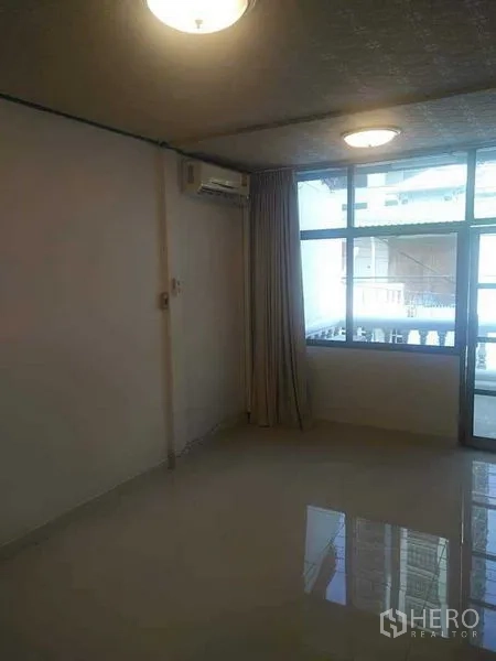 Townhouse for rent - Spacious room with glossy floor, big window, curtains, and balcony access.