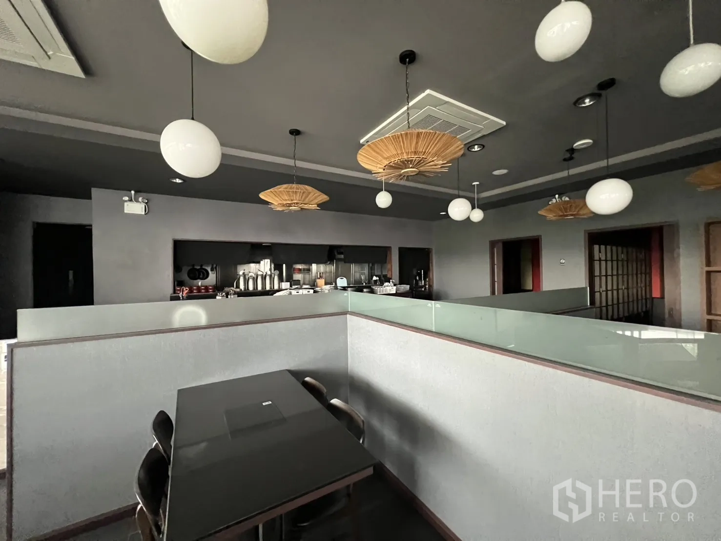 Retail Space for rent in Watthana, Bangkok - Open kitchen counter with globe pendant lighting, dark ceiling, and seating in a fitted retail space.