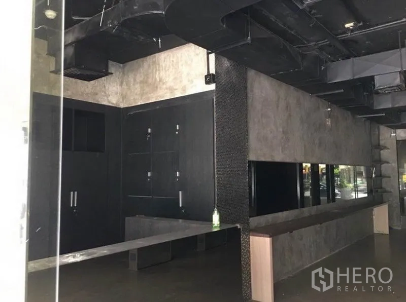 Office Space for rent in Pathum Wan, Bangkok - Long workspace with polished concrete finishes, mirrors and exposed ventilation ducts.