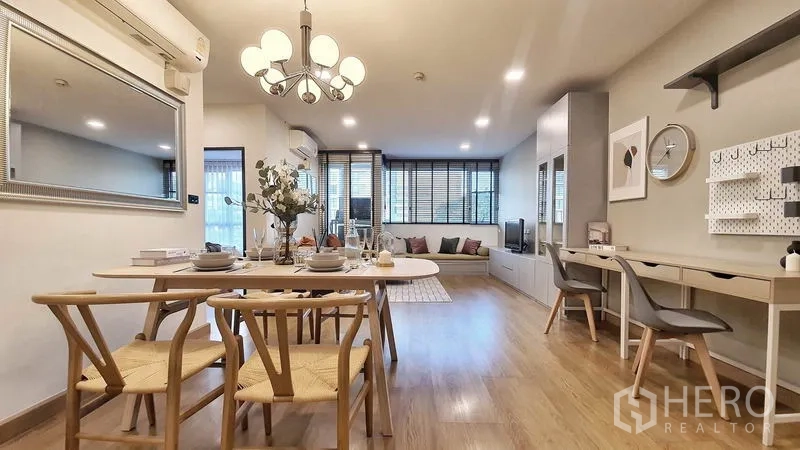 Condominium for rent in Khlong Toei, Bangkok - View from dining to living area with chandelier, long TV console, study desk and wide windows with blinds.