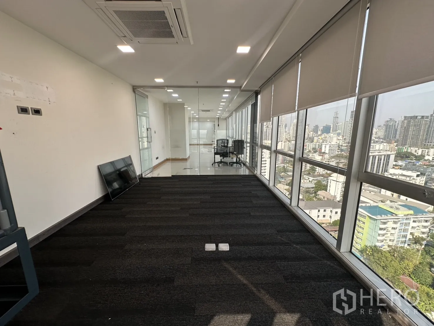 办公空间 出租 - 地毯房间望向玻璃隔断与窗墙，俯瞰城市
