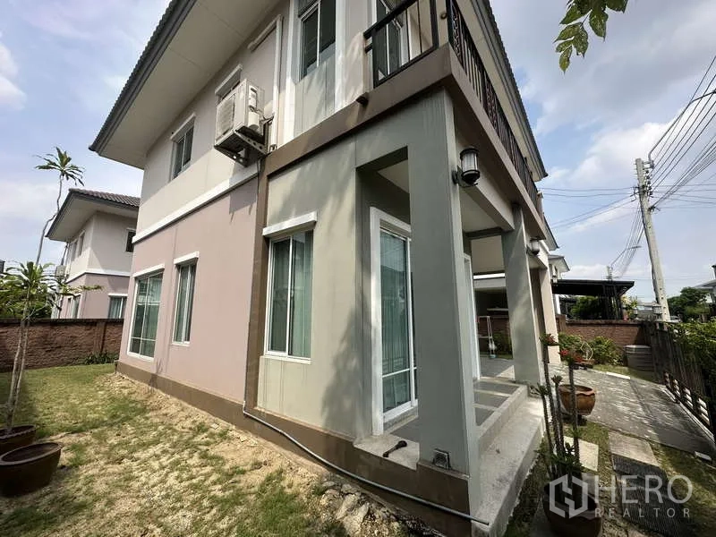 独立式住宅 出售在Sai Mai, Bangkok - 侧面柱廊，推拉玻璃门与通往花园的小径。