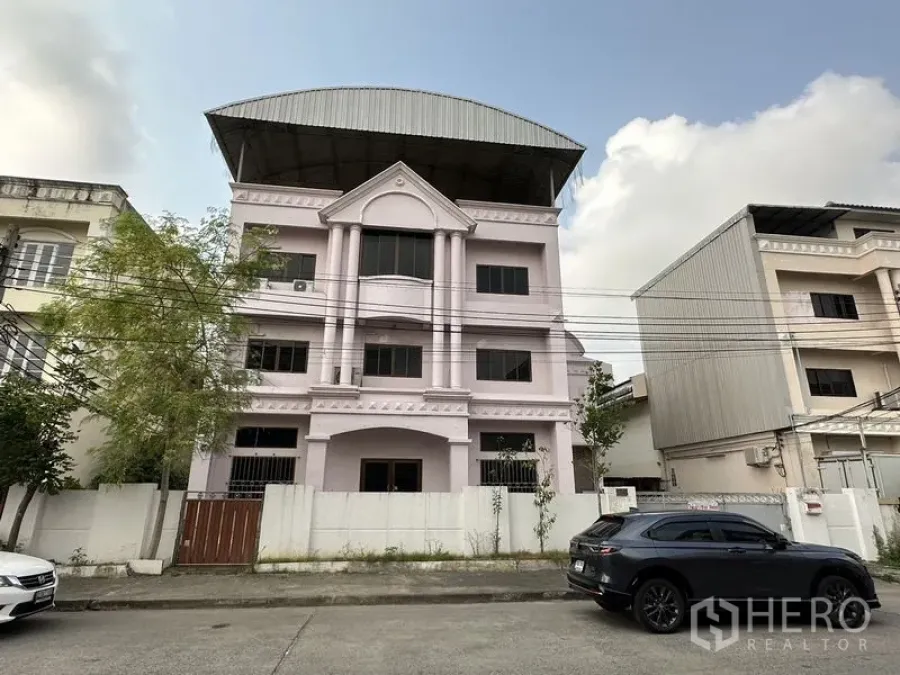 工厂 for rent in Bang Bua Thong, Nonthaburi - 三层工厂办公楼立面，带前院围栏和大屋檐。