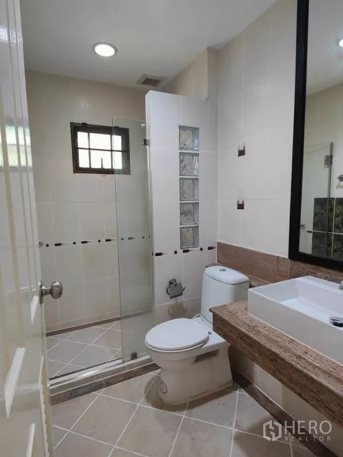 Detached House for rent or sale in Mueang Nonthaburi, Nonthaburi - Bathroom with glass shower enclosure, vanity countertop and modern fittings.