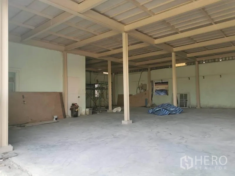 Warehouse for rent in Prawet, Bangkok - Open-plan warehouse interior in Prawet with steel roof, concrete floor, and support columns.