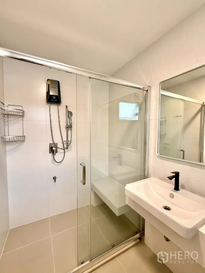 Detached House for rent in Bang Phli, Samut Prakan - Bathroom with glass shower enclosure, wall-mounted sink and water heater.