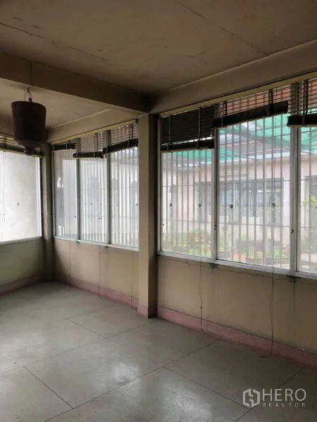 店屋 出租在Khlong Toei, Bangkok - 封闭阳台，百叶窗，可见邻近建筑。