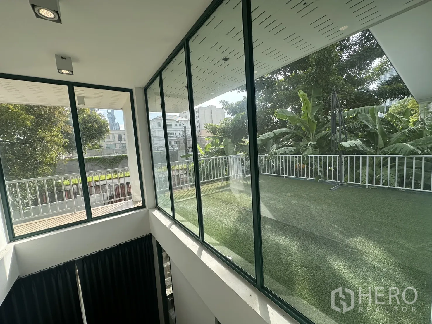 带办公室的家 出租或出售在Phra Khanong, Bangkok - 楼梯间大玻璃窗，眺望人造草坪露台