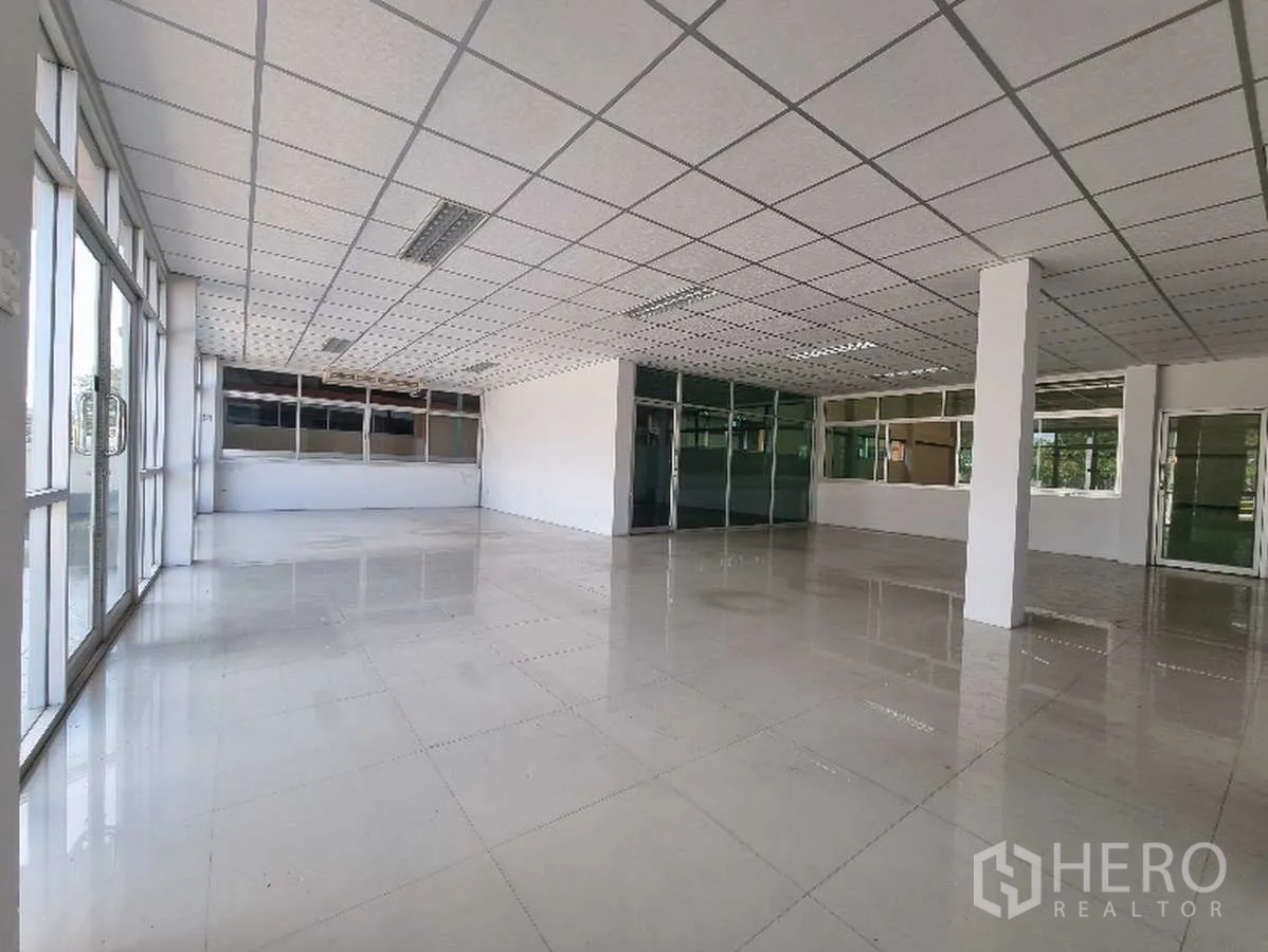 Factory for rent in Samut Prakan - Bright open-plan office with tiled floors and grid ceiling.