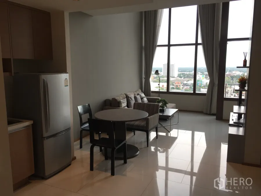 Condominium for rent in Khlong Toei, Bangkok - Bright living area with floor-to-ceiling windows and city view in a Sukhumvit condo
