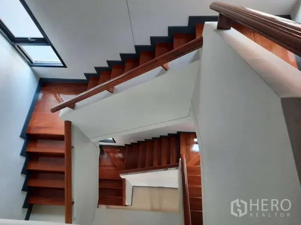 Home Office for rent in Huai Khwang, Bangkok - View down a polished wooden staircase with white walls and side windows.