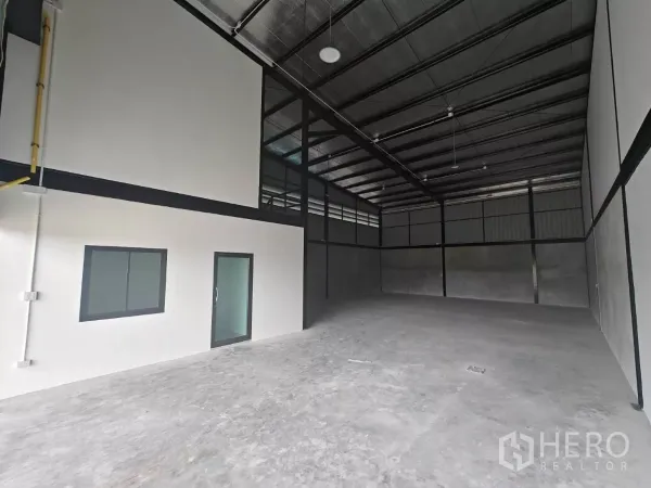 Warehouse for rent in Sam Phran, Nakhon Pathom - Spacious warehouse interior with high ceiling, insulated roof and a separate office block.