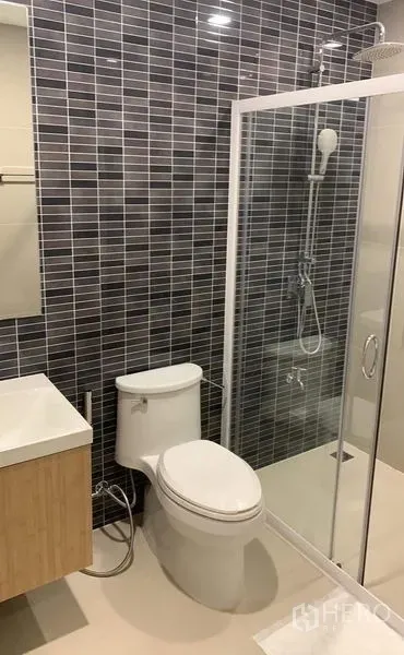 Townhouse for rent in Thanyaburi, Pathum Thani - Modern bathroom with glass shower enclosure, tiled walls, and vanity.