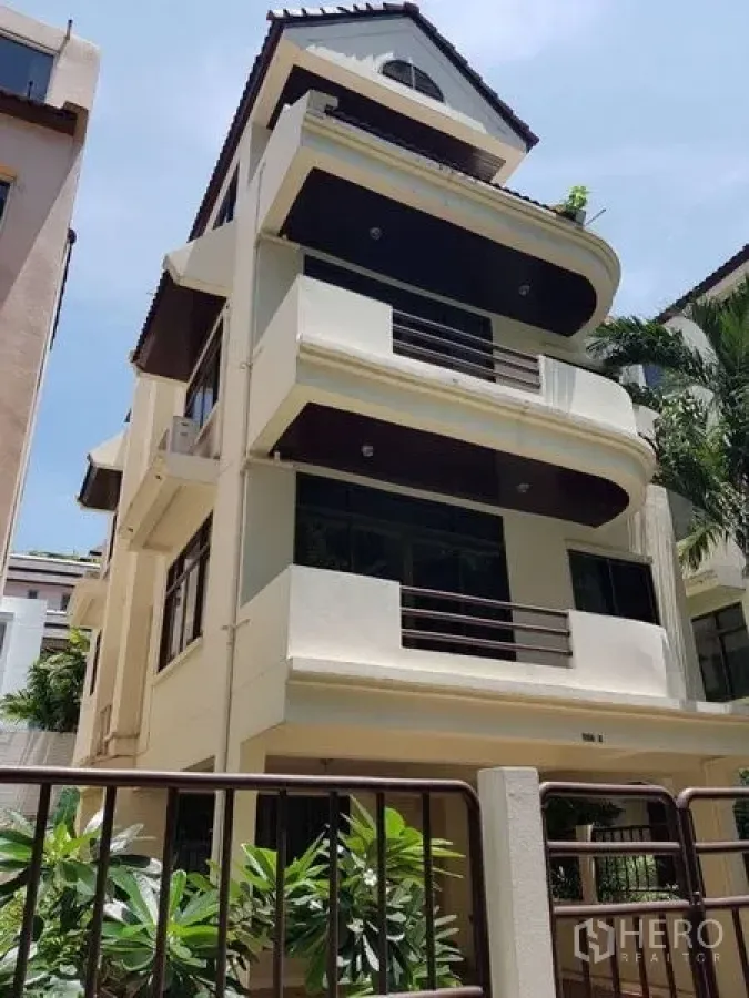 Detached House for rent in Watthana, Bangkok - Multi-storey detached house exterior with curved balconies and metal gate.