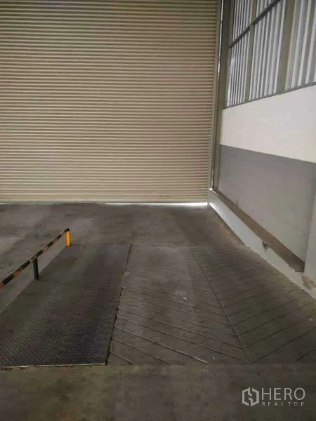 Warehouse for rent in Lat Krabang, Bangkok - Indoor loading dock ramp facing a closed roller shutter