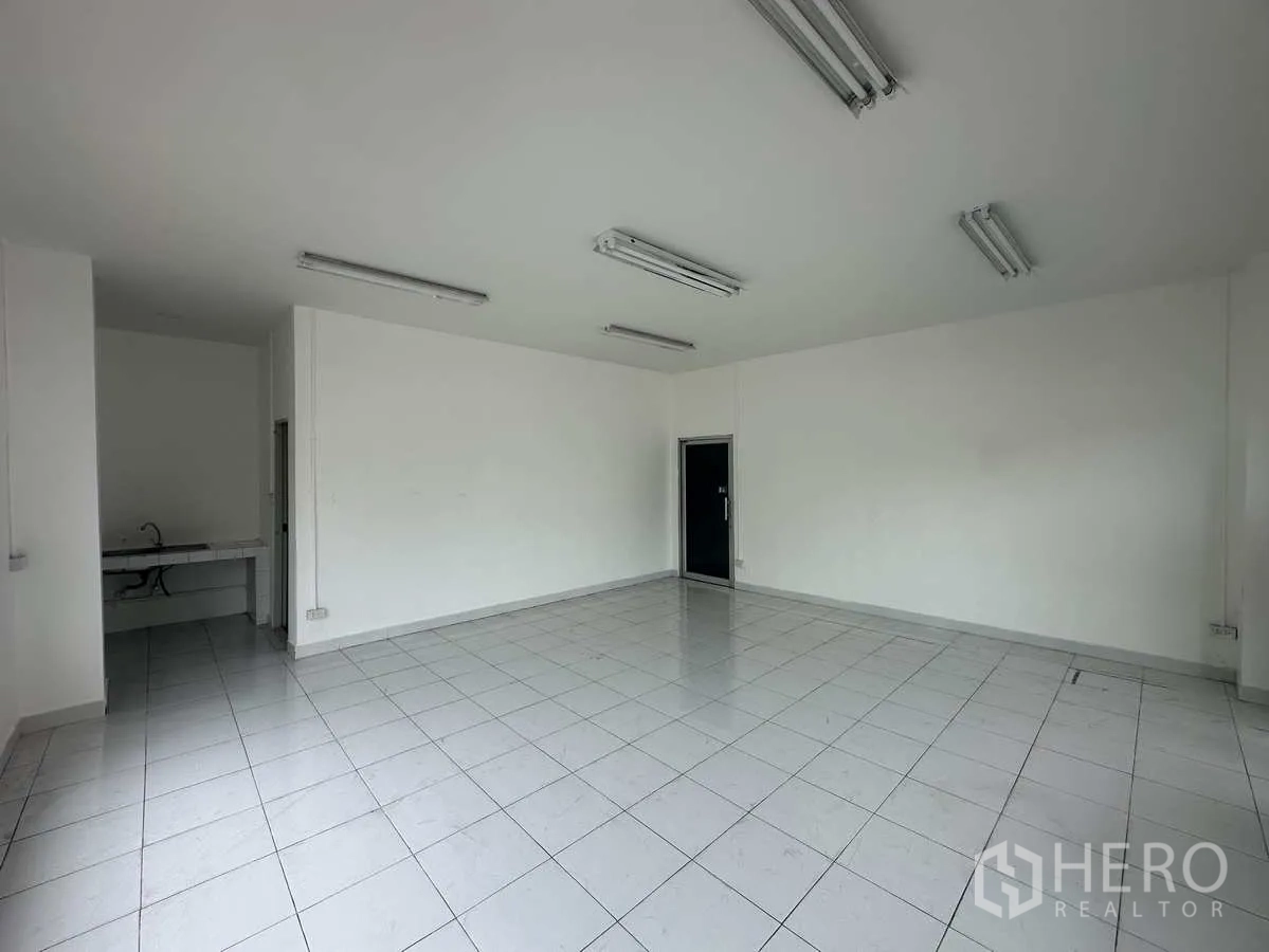 Warehouse for rent in Phra Nakhon Si Ayutthaya - Bright office room with white tiled flooring, white walls and fluorescent lighting.