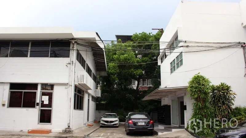 Office Space for rent in Suan Luang, Bangkok - Two white low-rise office buildings with on-site parking and greenery