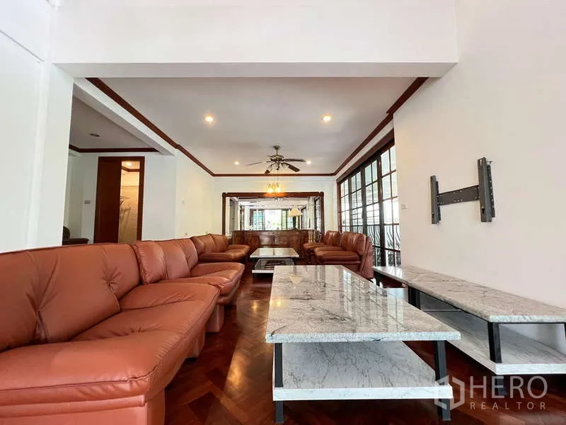Detached House for rent in Chatuchak, Bangkok - Bright living room with leather sofas, marble tables and parquet floor.