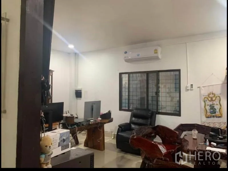 货栈 出租在Sai Noi, Nonthaburi - 办公室另一角，皮椅、格栅窗与分体空调