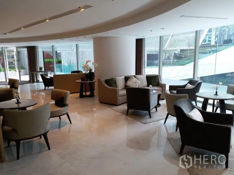 Condominium for rent in Pathum Wan, Bangkok - Elegant condominium residents’ lounge with plush seating and floor-to-ceiling glass.