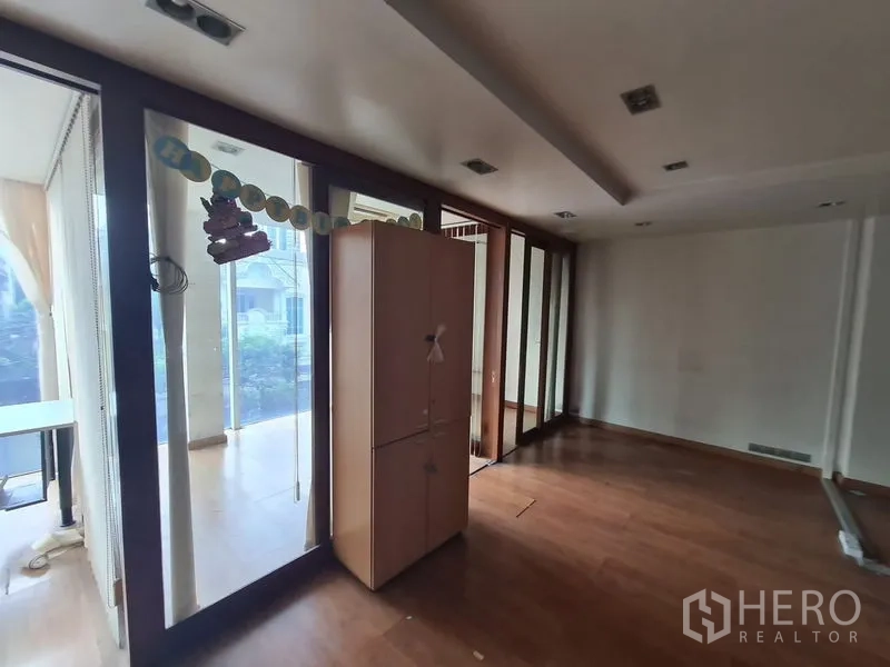 Office Space for rent in Bang Rak, Bangkok - Corner workspace with floor-to-ceiling windows and freestanding cabinet.