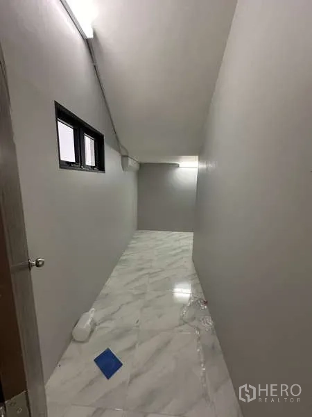 Factory for rent or sale in Lam Luk Ka, Pathum Thani - Narrow utility corridor with marble-look tiles and small windows.