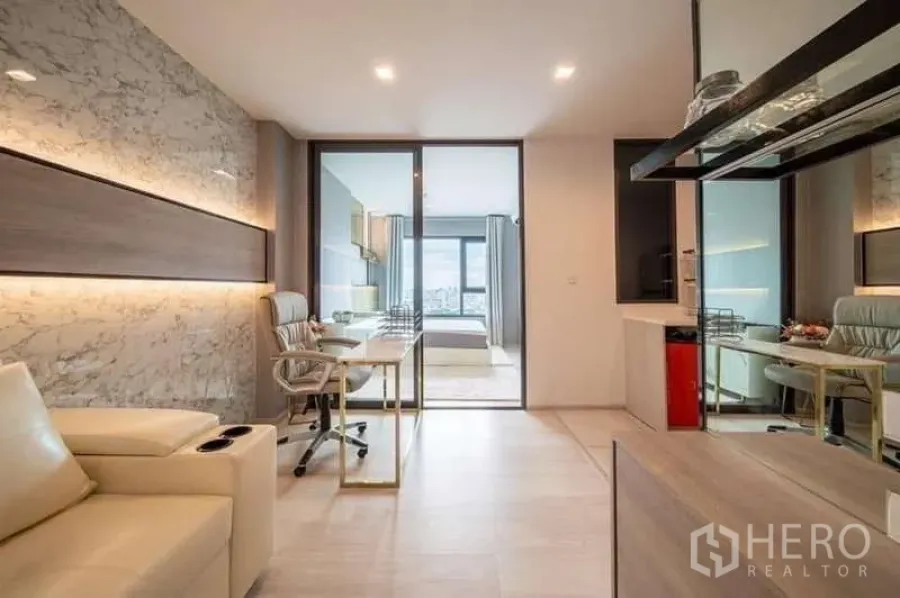 Condominium for rent or sale in Pathum Wan, Bangkok - Bright living room with marble feature wall, glass partition to the bedroom, and distant city view.