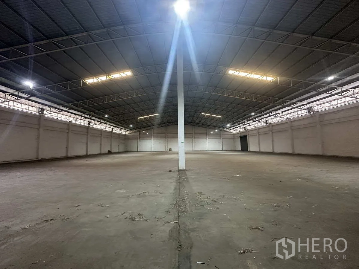 Warehouse for rent in Phra Nakhon Si Ayutthaya - Symmetrical view of a large warehouse bay with a central column and roller door at the end.