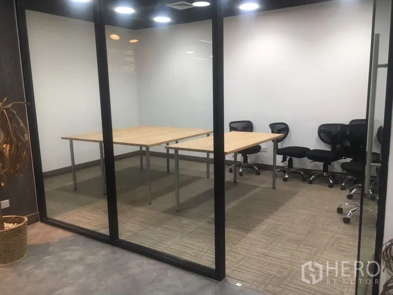 Office Space for rent in Sathon, Bangkok - Glass-walled meeting room with rectangular tables and swivel chairs on carpet flooring.