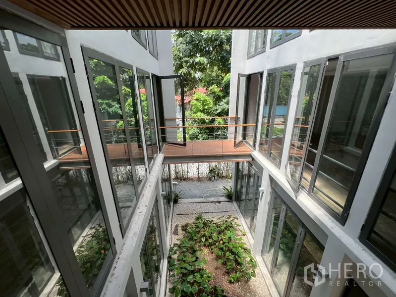 Home Office for rent or sale in Phra Khanong, Bangkok - View into the green atrium courtyard with glass walls and sky bridge.