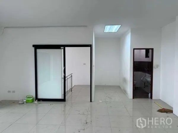 Factory for rent or sale in Bang Phli, Samut Prakan - Office level corridor with frosted sliding door, stair access, and a small restroom.