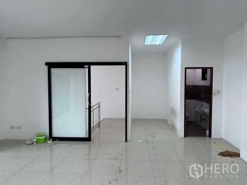 Factory for rent or sale in Bang Phli, Samut Prakan - Office level corridor with frosted sliding door, stair access, and a small restroom.