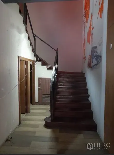 Shophouse for rent - Interior corridor with solid wooden staircase leading to upper level and service rooms.