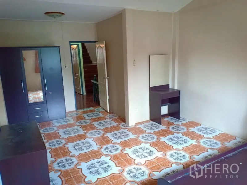 Townhouse for rent in Phra Khanong, Bangkok - Spacious bedroom with patterned floor tiles, wardrobe and dressing table.