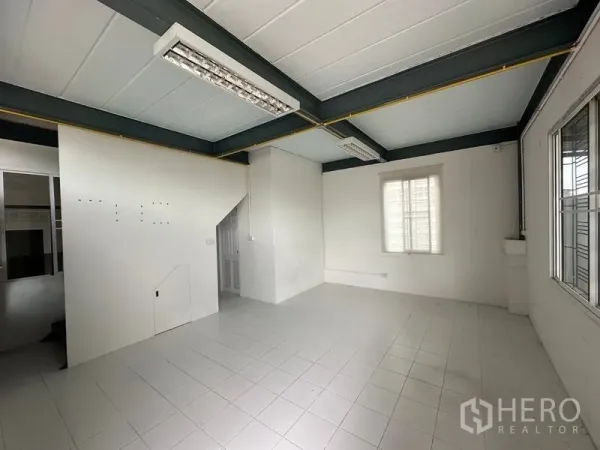 Factory for rent in Bang Bua Thong, Nonthaburi - Bright second-floor office with tiled flooring, fluorescent lighting and window, connected by internal stairs.