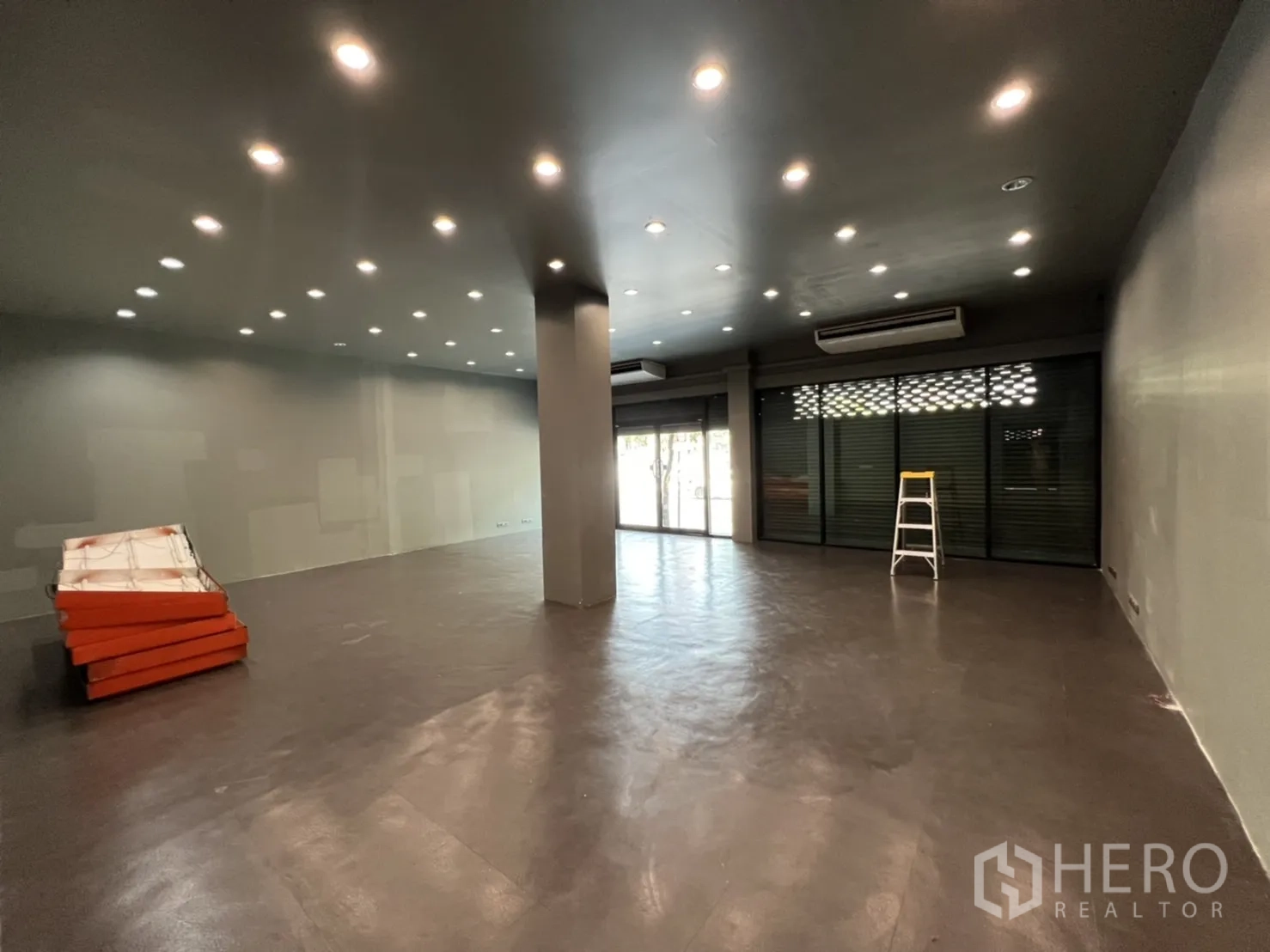 店屋 出租在Phra Khanong, Bangkok - 开放式营业空间，射灯天花，大面积玻璃橱窗配卷帘门与空调
