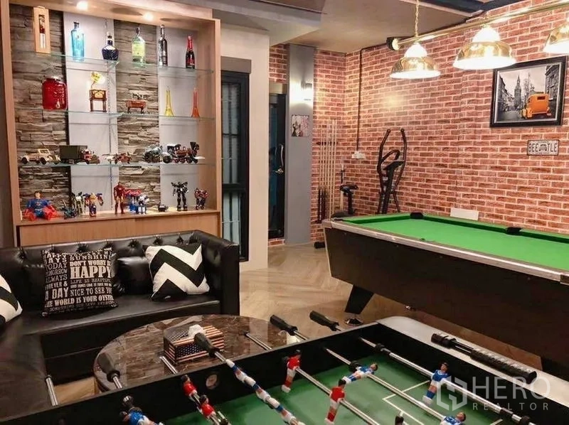 Detached House for sale in Lam Luk Ka, Pathum Thani - Stylish game room featuring brick accent walls, pool table, foosball table and display shelving.
