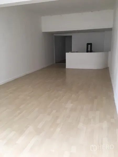 Shophouse for rent in Khlong Toei, Bangkok - Bright white-walled room with light wood floors and a compact reception counter at the rear.