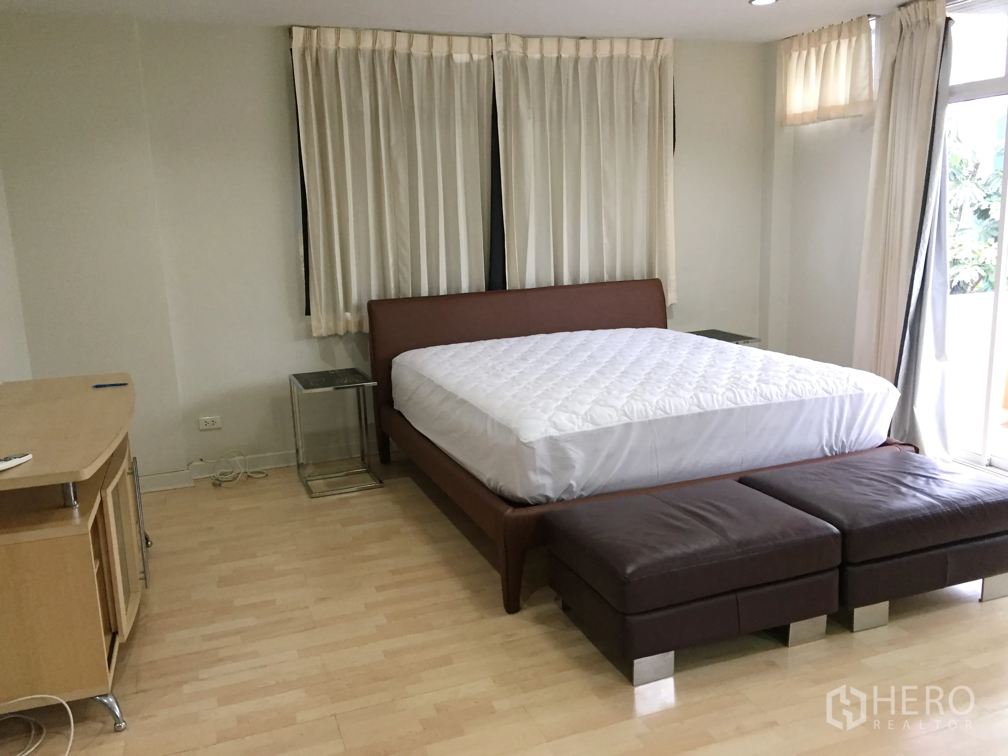 Detached House for rent in Watthana, Bangkok - Spacious master bedroom with large bed, full-height windows and balcony access.