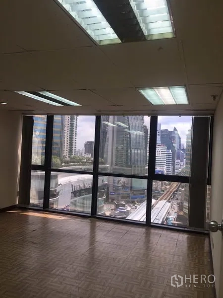 Office Space for rent in Watthana, Bangkok - Open office with floor-to-ceiling windows overlooking BTS line and high-rise buildings.