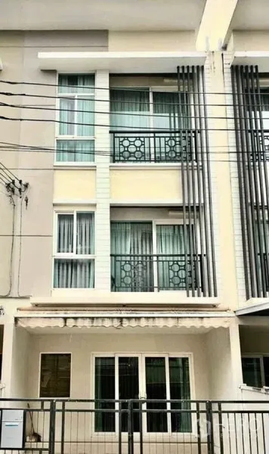 Townhouse for sale in Bang Kapi, Bangkok - Modern three-storey townhouse exterior with small balconies and decorative metal railings.