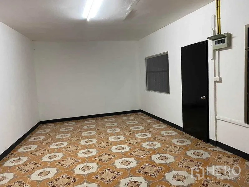 Warehouse for rent in Saphan Sung, Bangkok - Simple office room inside the warehouse with patterned tile flooring, white walls, window, and door.