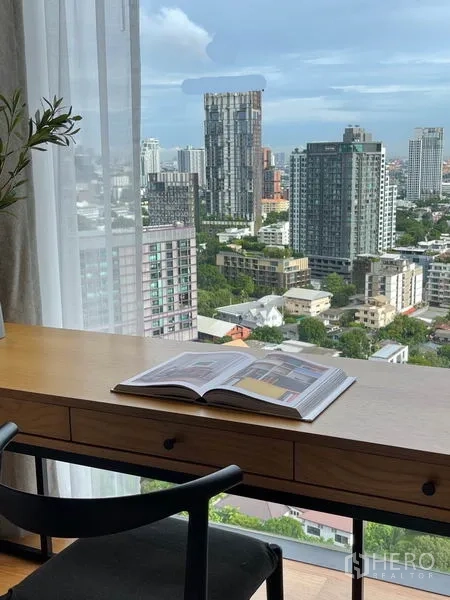Condominium for rent in Khlong Toei, Bangkok - Work desk by a large window offering an unobstructed Bangkok skyline view.