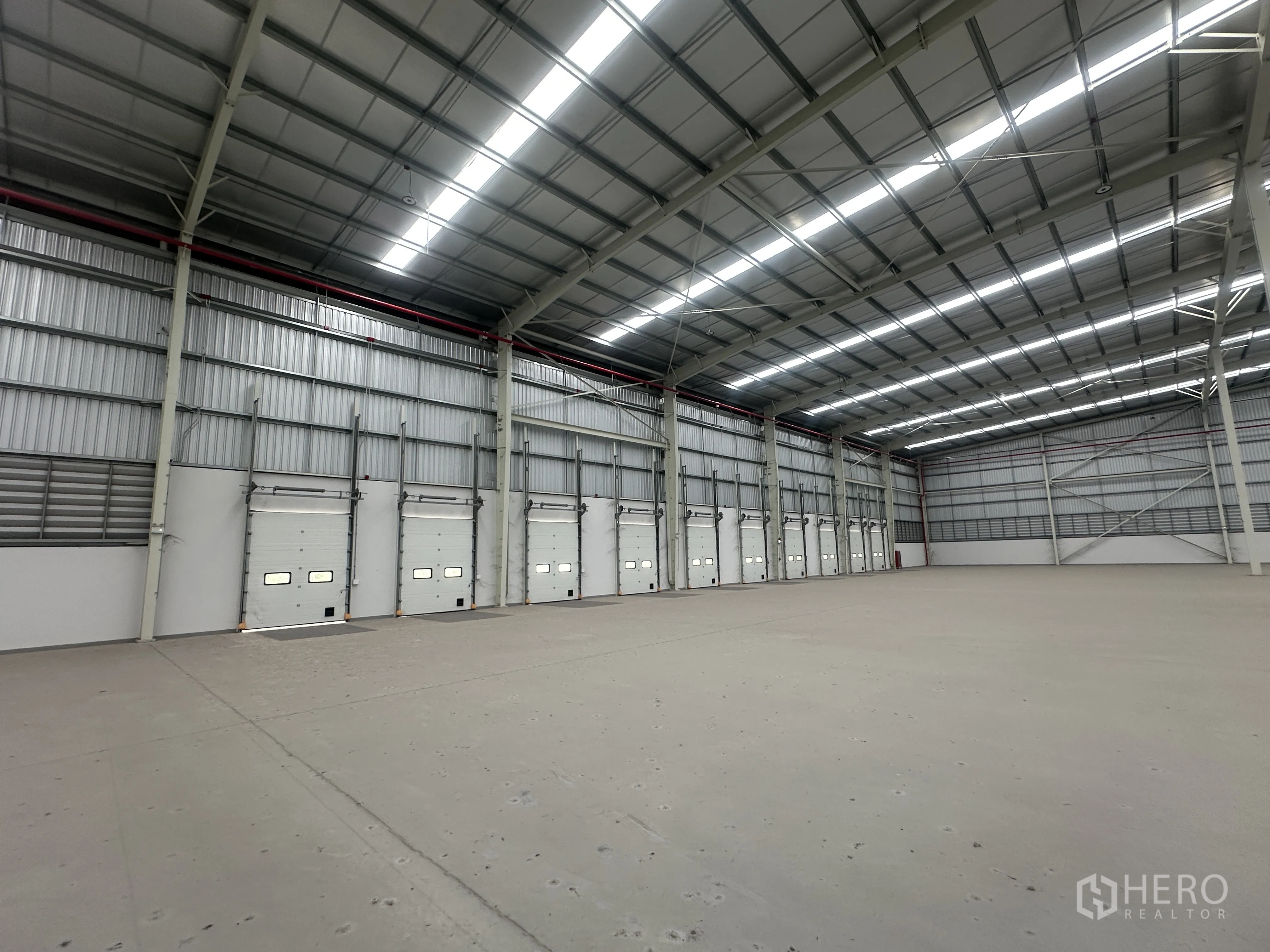 Warehouse for rent in Mueang Chon Buri, Chon Buri - Row of dock-high loading doors along an interior wall of the warehouse.