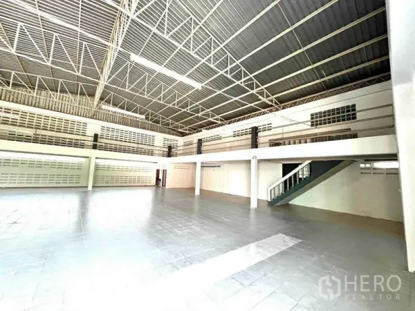Warehouse for rent in Bang Phli, Samut Prakan - Open floor area with mezzanine level and staircase for additional storage or office space.