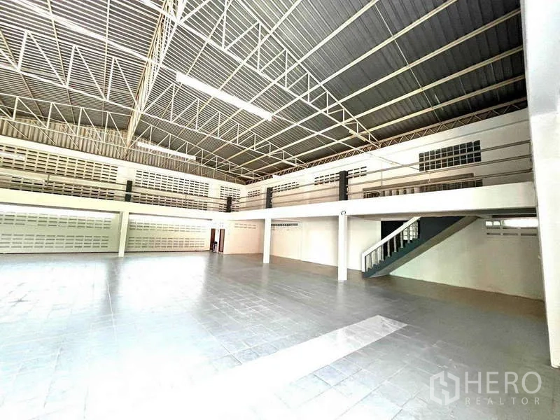 Warehouse for rent in Bang Phli, Samut Prakan - Open floor area with mezzanine level and staircase for additional storage or office space.