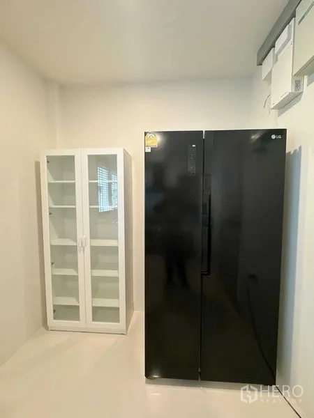 Detached House for rent or sale - Utility room with black double-door refrigerator and white storage cabinet.